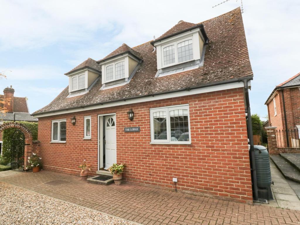 a red brick house with white windows at The Lodge off High Street in Hadleigh