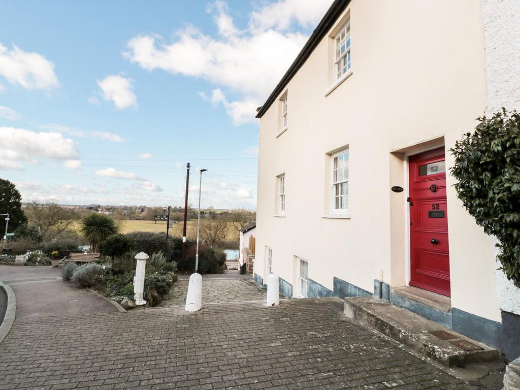 a red door on the side of a white building at Wye View in Ross on Wye