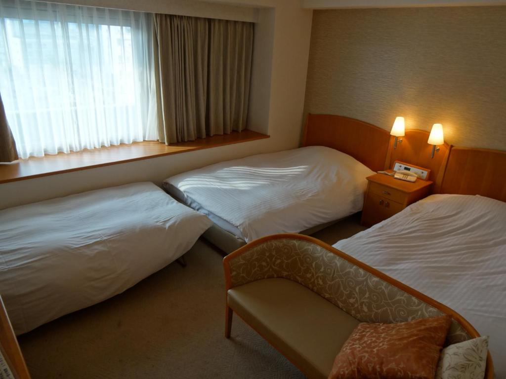 Postel nebo postele na pokoji v ubytování Kobe Luminous Hotel