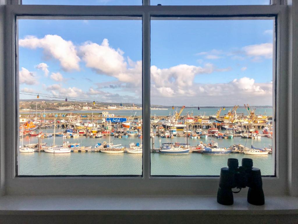 een raam met uitzicht op een haven met boten bij Westcliff in Penzance