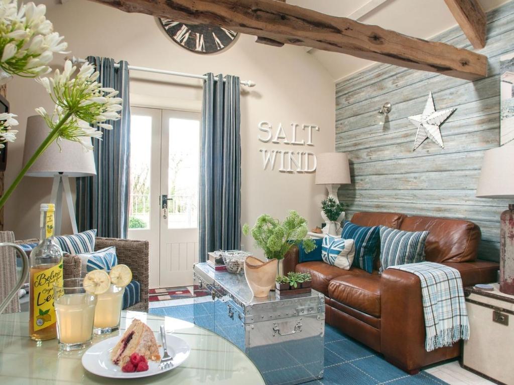 a living room with a leather couch and a table at Saltwind Granary in Hartland