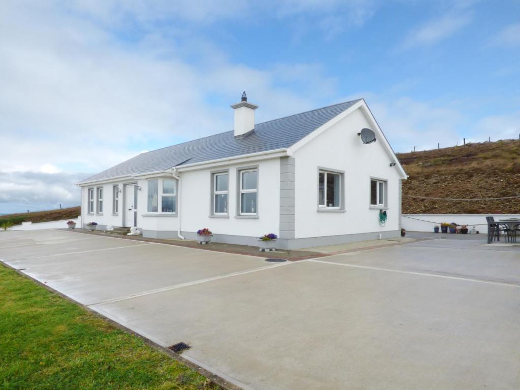 a white house with a parking lot at Gelmar's Coastal View in Malin