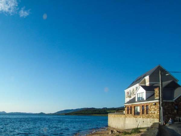 a house on the shore of a body of water at The Beach House Apartment in Buncrana