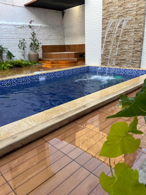 a swimming pool in a yard next to a house at Hotel Lider in Santa Cruz de la Sierra