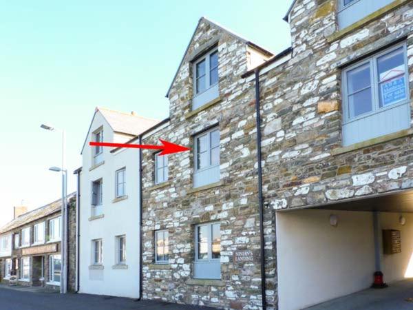 a brick building with a red arrow on it at The Clamshell in Isle of Whithorn