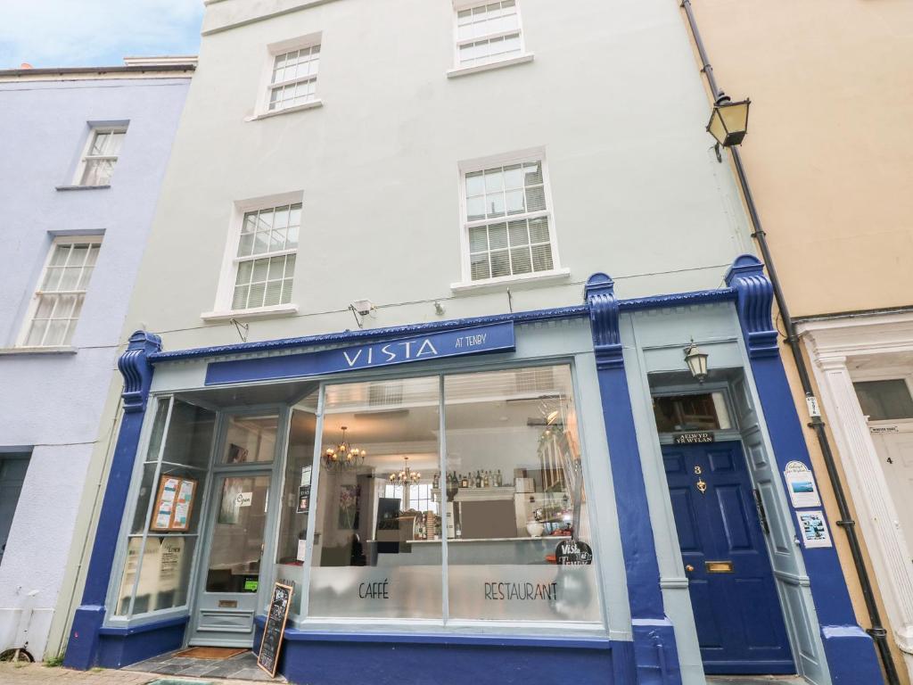 a store front of a white building with blue trim at Apartment 2 in Tenby