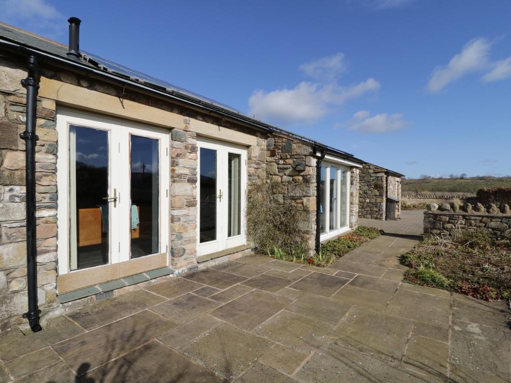 an external view of a stone cottage with windows at Buttermere in Cockermouth