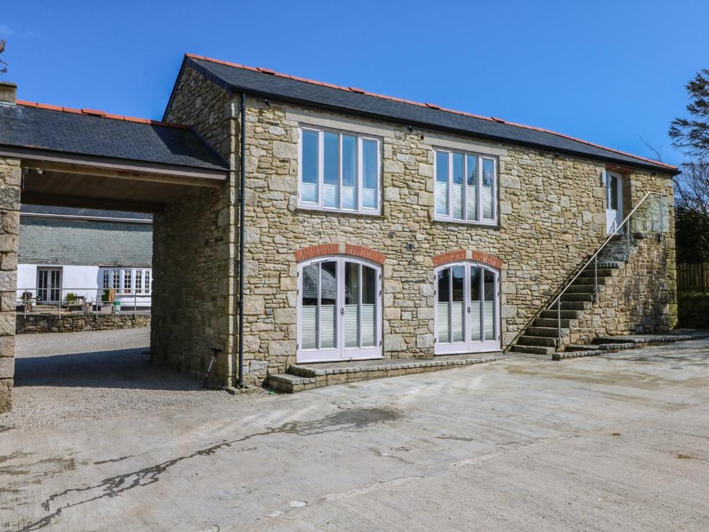 a brick house with white windows and a garage at Dexter in Penryn