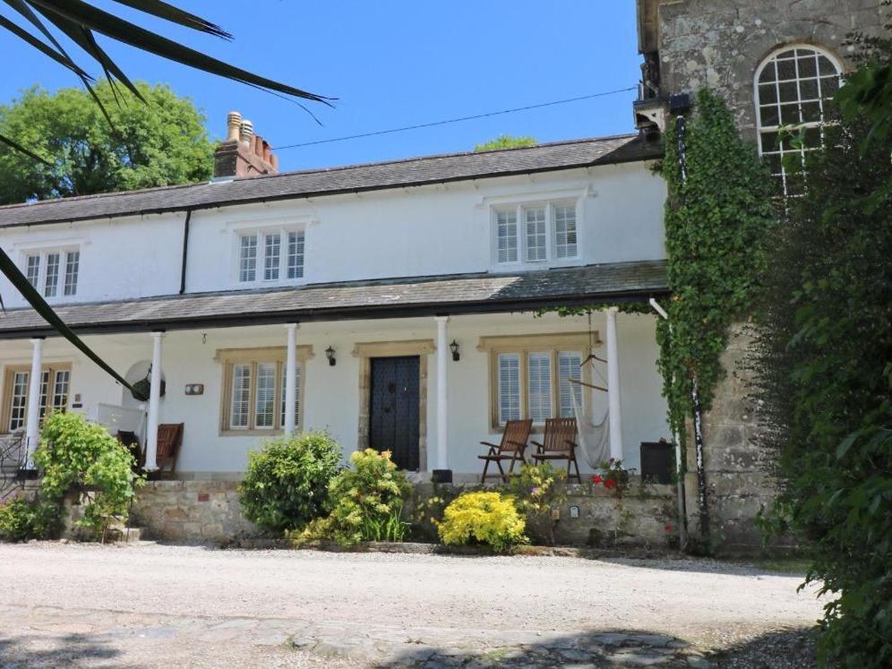 an old white house with chairs in front of it at Sea Cliff Cottage in Pentewan