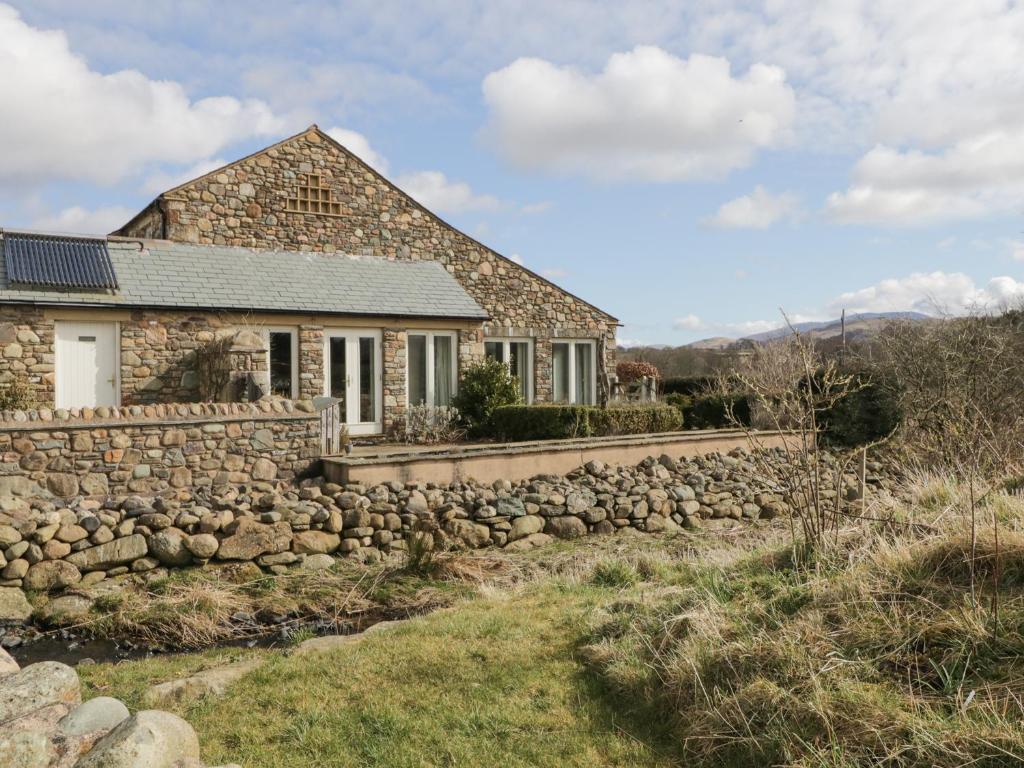 a stone house with a stone wall at Beckside in Cockermouth
