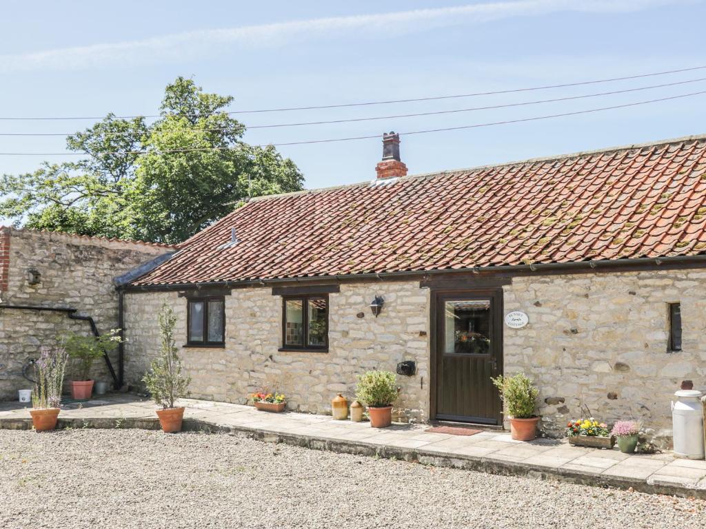 an old stone cottage with a green door at Sunset Cottage in Great Edston