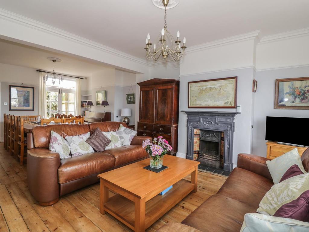 a living room with leather furniture and a fireplace at Lighthouse View in Great Yarmouth