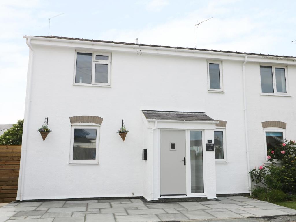 a white house with a courtyard at 21 Llwyn Gwalch Estate in Pwllheli