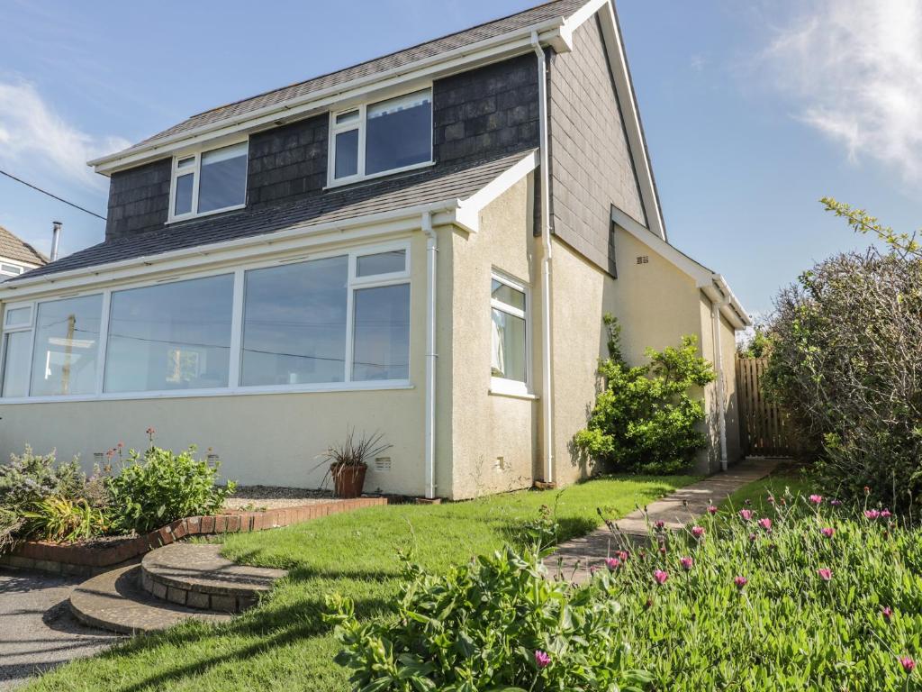 a house with a garden in front of it at Crantock Bay House in Crantock