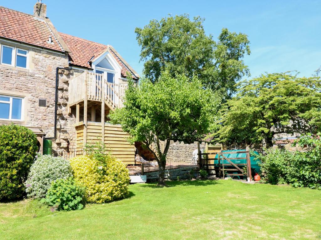 a house with a deck and a tree in the yard at The Loft at Lucott House in Bath