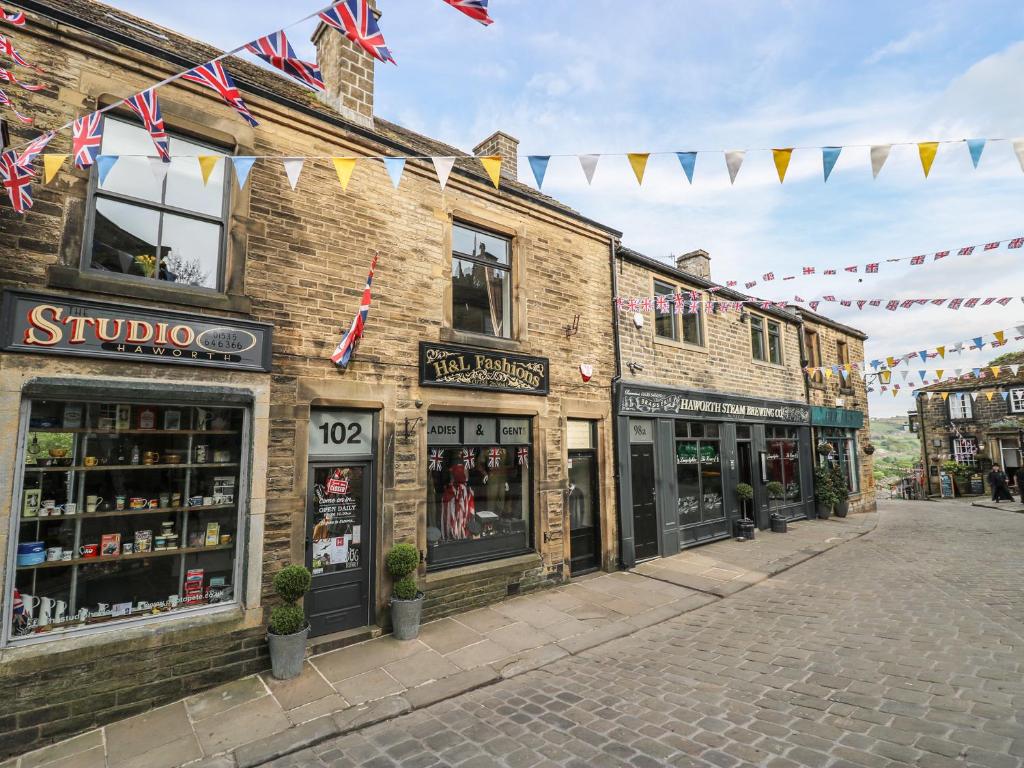 a street with shops and flags on a building at The Attic in Keighley