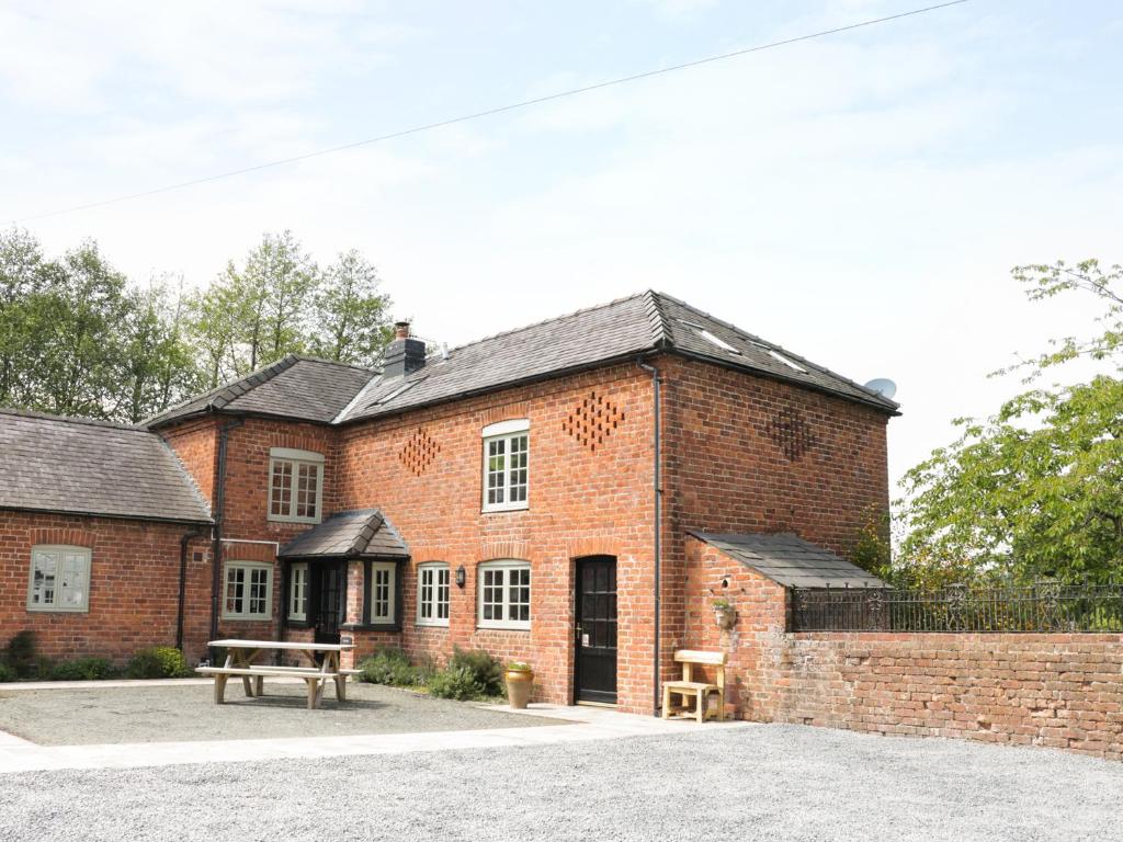 a brick building with a bench in front of it at Garden Cottage in Kerry