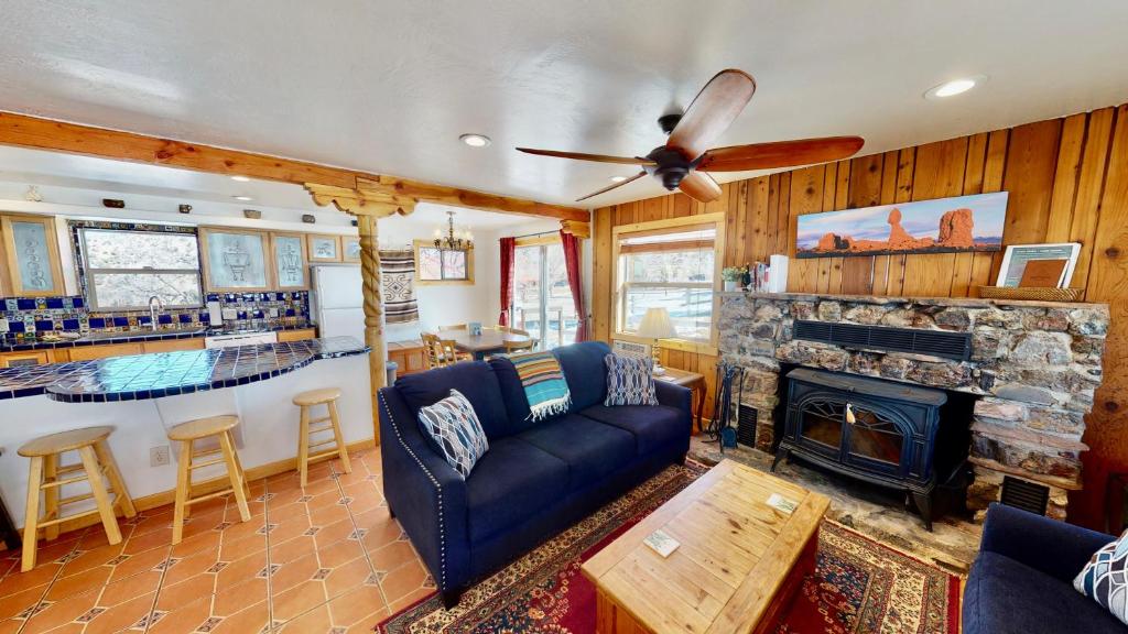 - un salon avec un canapé bleu et une cheminée dans l'établissement Pack Creek ~ Farm House, à Moab
