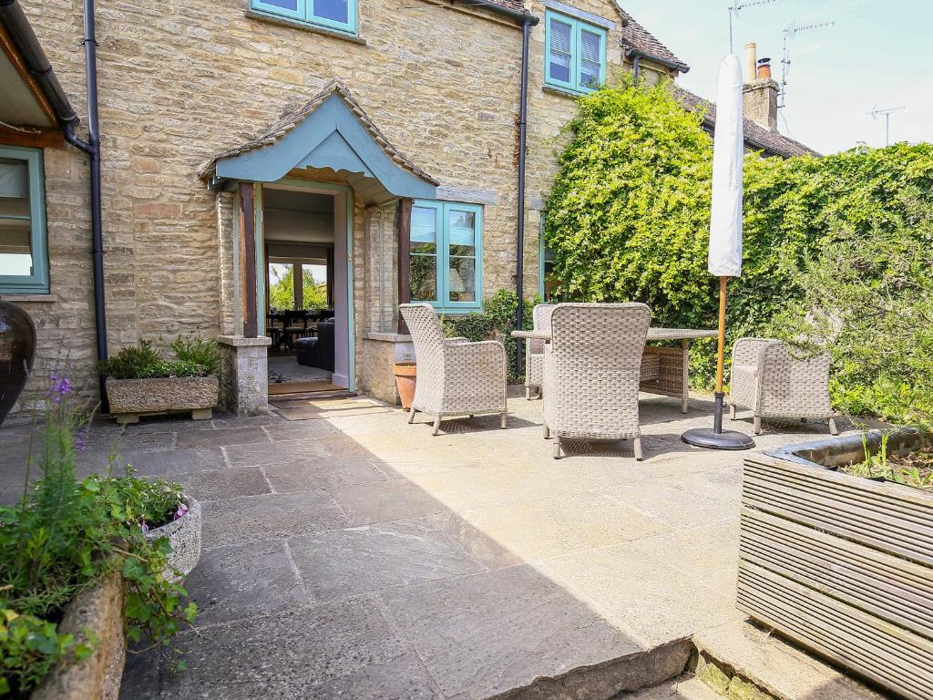 a patio with chairs and a table in front of a building at Fairview Cottage in Burford