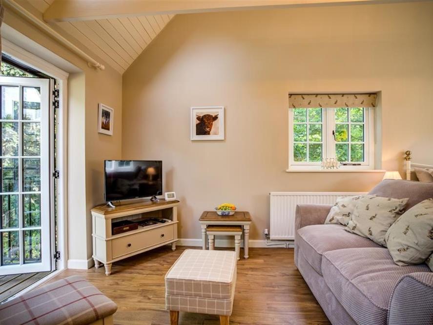 a living room with a couch and a tv at Lime Tree in Burford