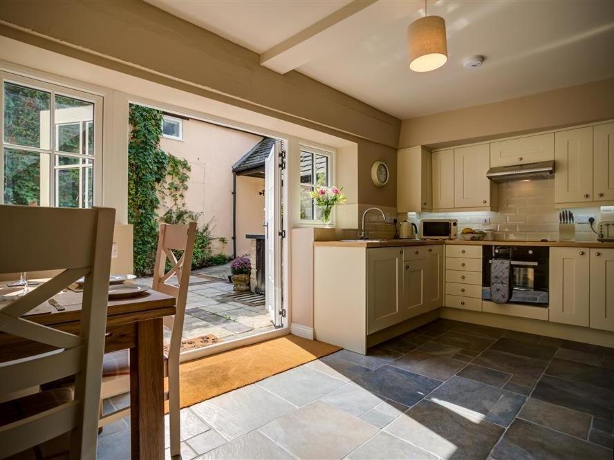 a large kitchen with a table and a window at Mill Race in Burford