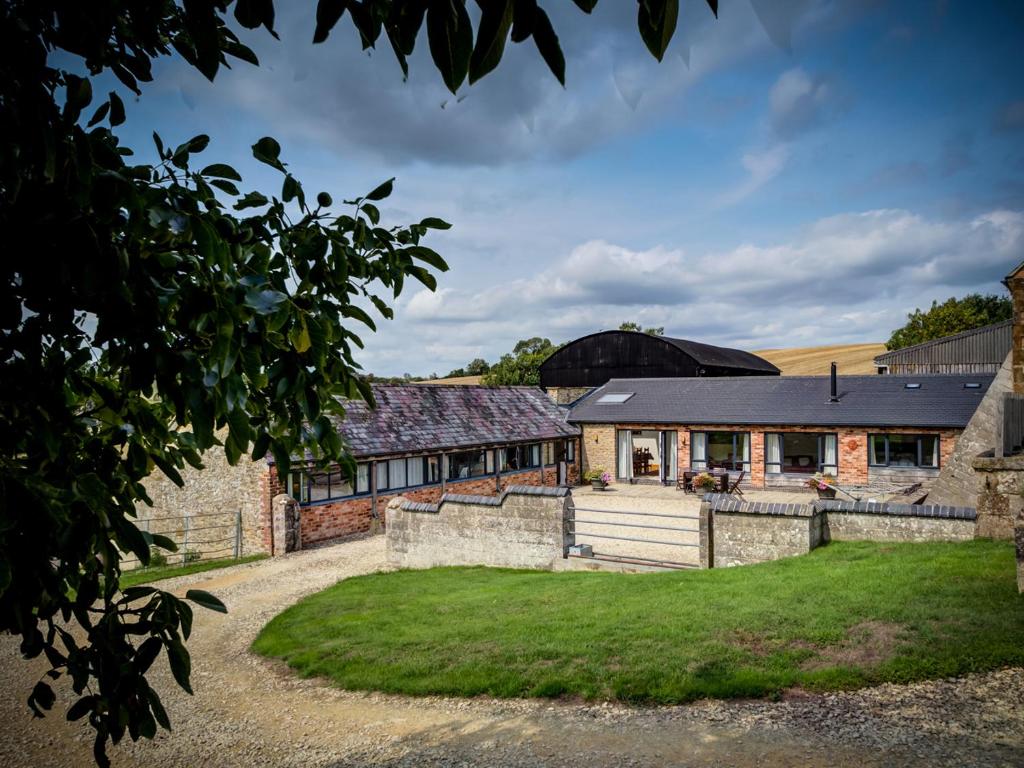 an exterior view of a farm house with a yard at Wytons Piece in Cherington