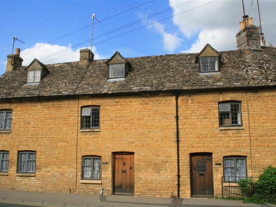 an old brick building with windows and a roof at Wadham Cottage in Bourton on the Water