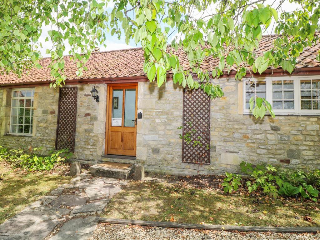 DyrhamにあるThe Campbell Cottageの茶色の木の扉のある石造りの家