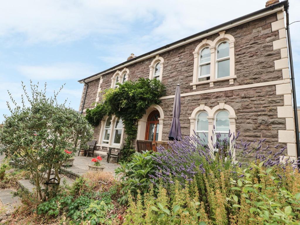 a stone house with a garden in front of it at Rosehill in Abergavenny