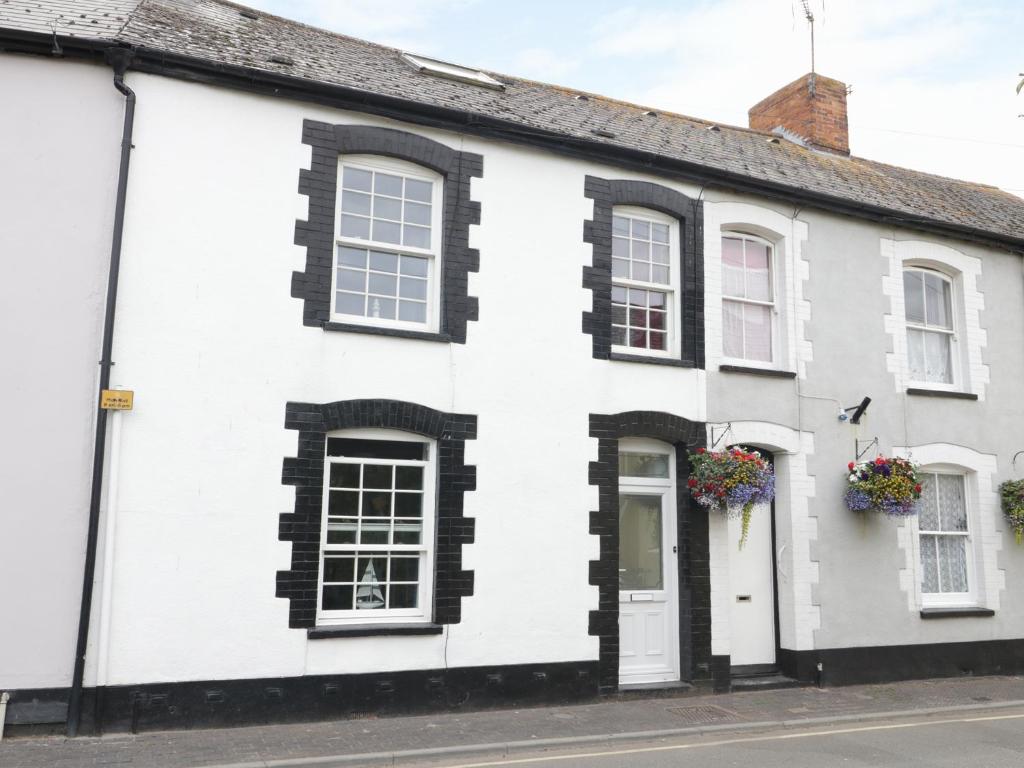 a white and black house with flowers on the windows at No 9, Watchet in Watchet
