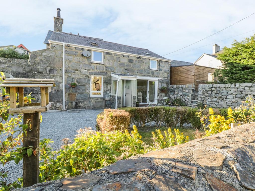 a stone house with a stone wall at Y Cilgwyn in Blaenau-Ffestiniog