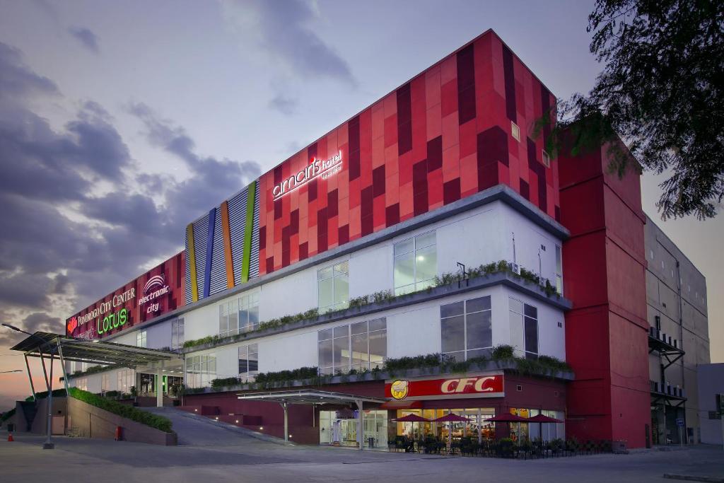 a red and white building with a cocacola at Amaris Hotel Ponorogo in Ponorogo