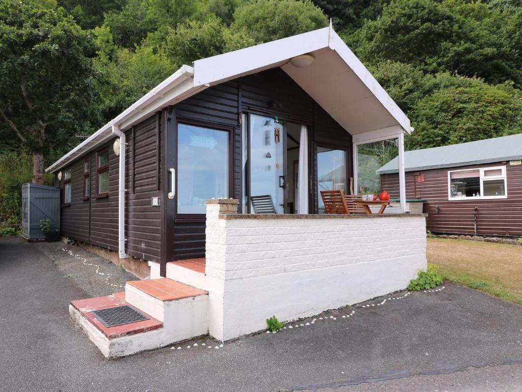 a small cabin with a porch and a door at Captain's Cabin in Aberystwyth