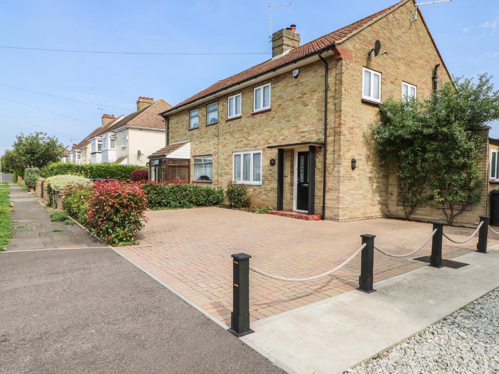 a brick house with a chain fence in front of it at Holly Tree House in Herne Bay