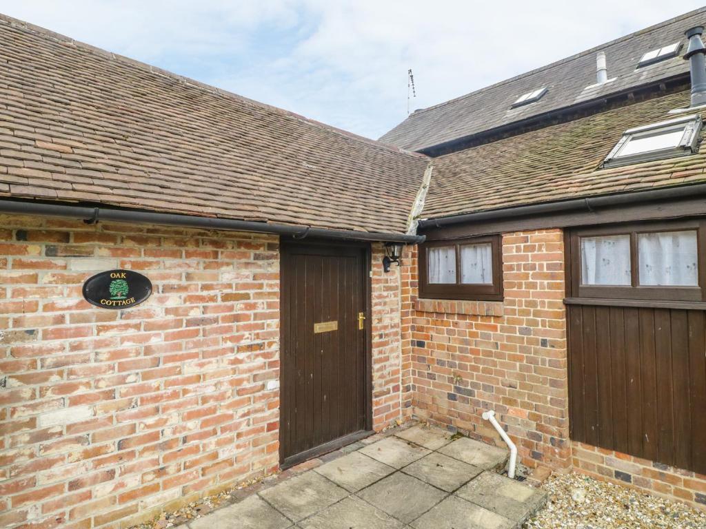 a brick house with two wooden garage doors at Oak Cottage in Wareham