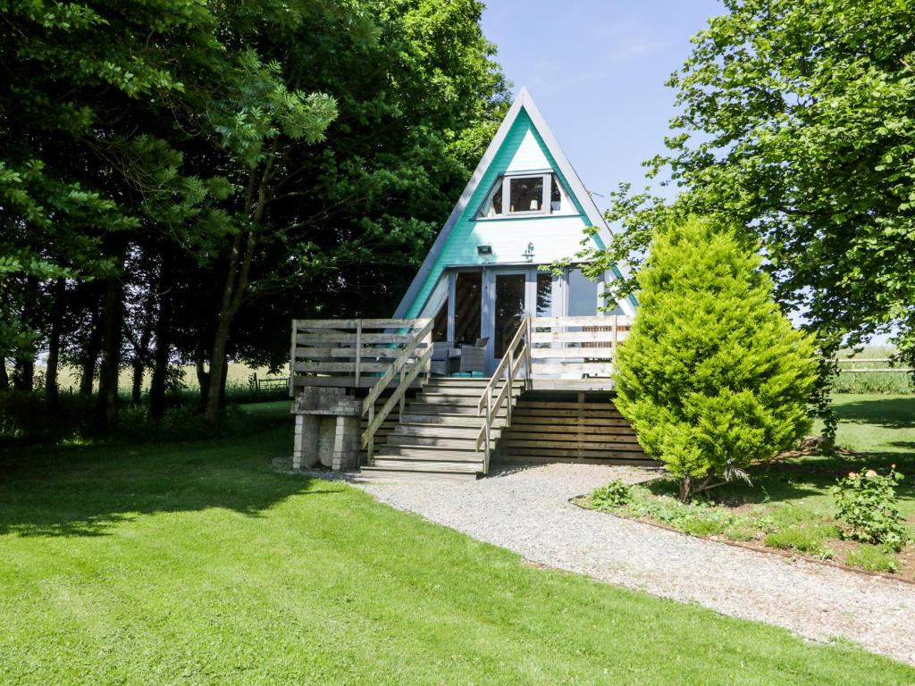 una pequeña casa con techo azul y escaleras en Apple Tree Lodge, en Gillingham