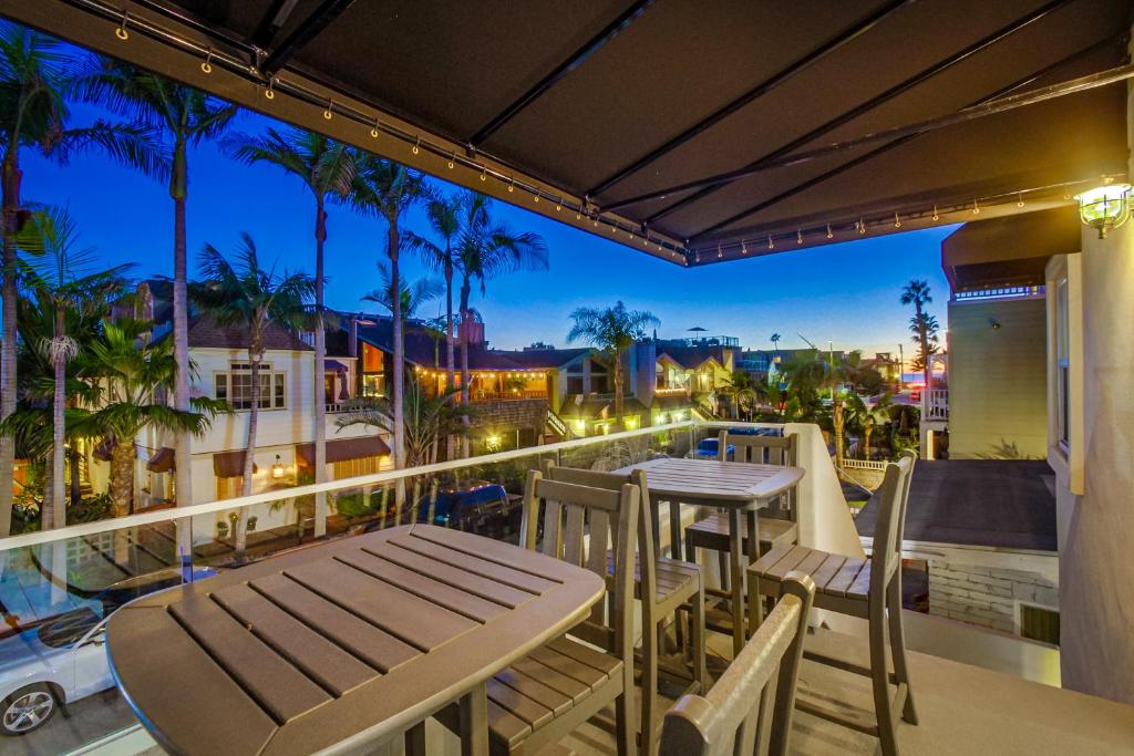 a patio with tables and chairs on a balcony at night at Capistrano Haven in San Diego