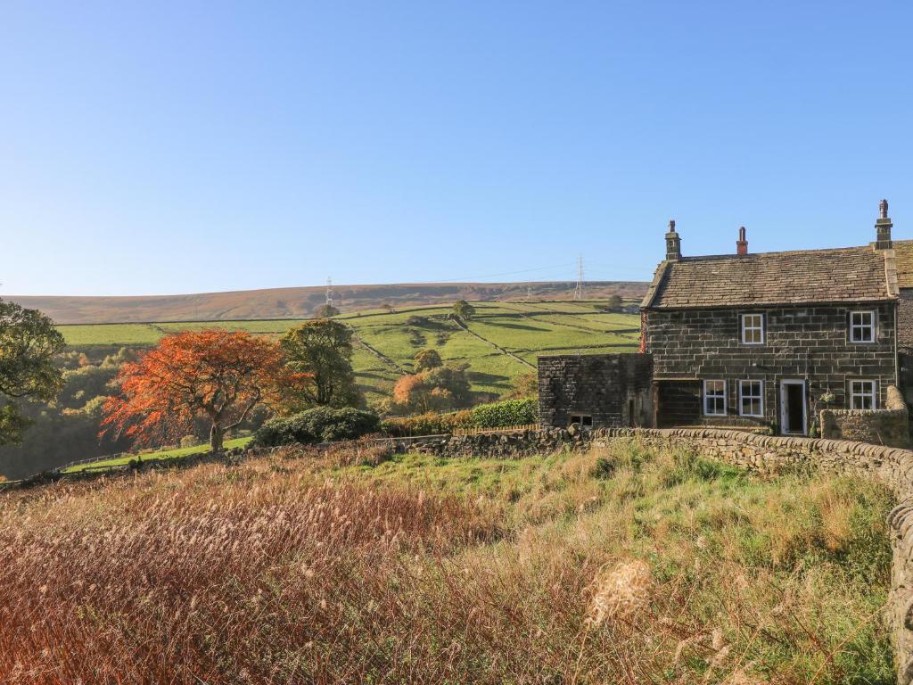 an old stone house on a hill in the countryside at The Cottage, Beeston Hall in Sowerby Bridge