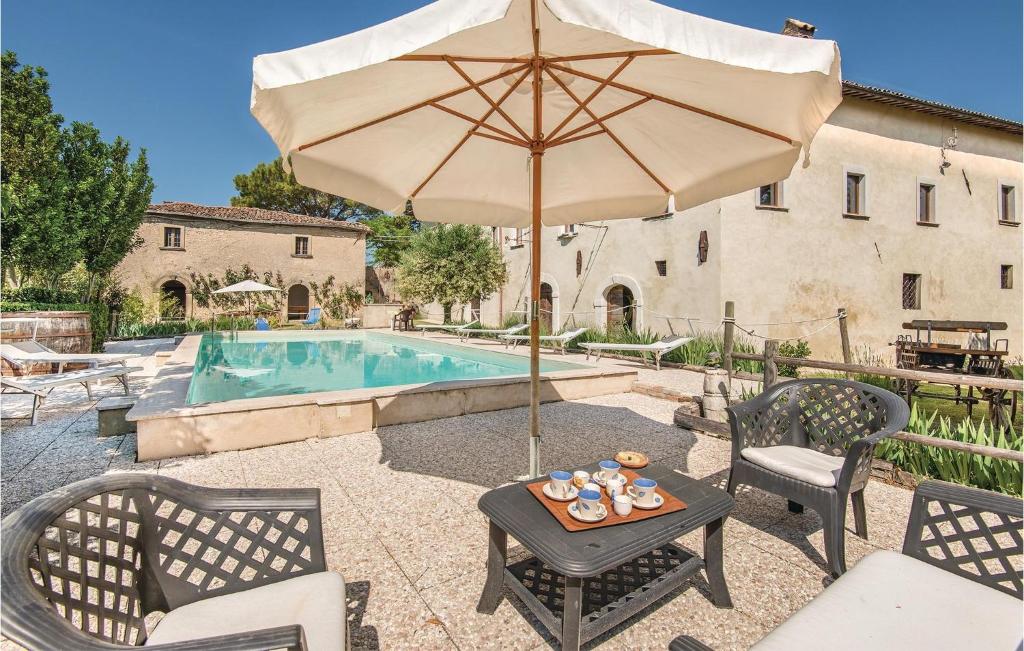 una mesa con sombrilla junto a la piscina en Cozy Home In Cantalice ri With Private Swimming Pool, Can Be Inside Or Outside, en Cantalice