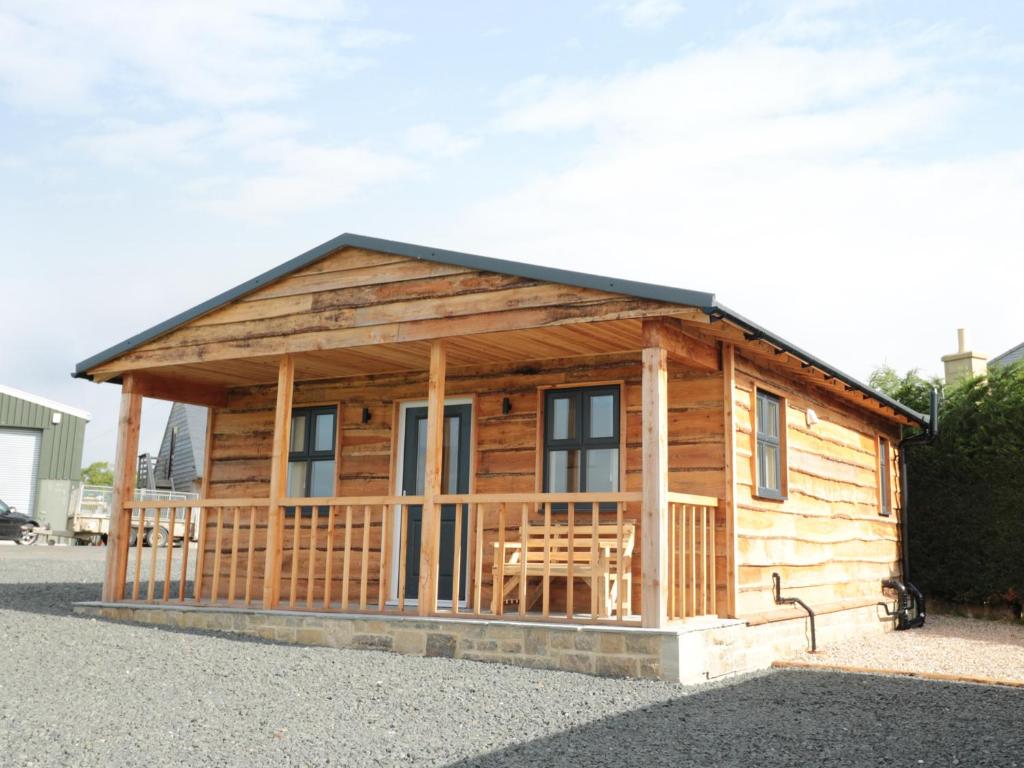 a wooden cabin with a table and chairs in it at Breamish in Longframlington