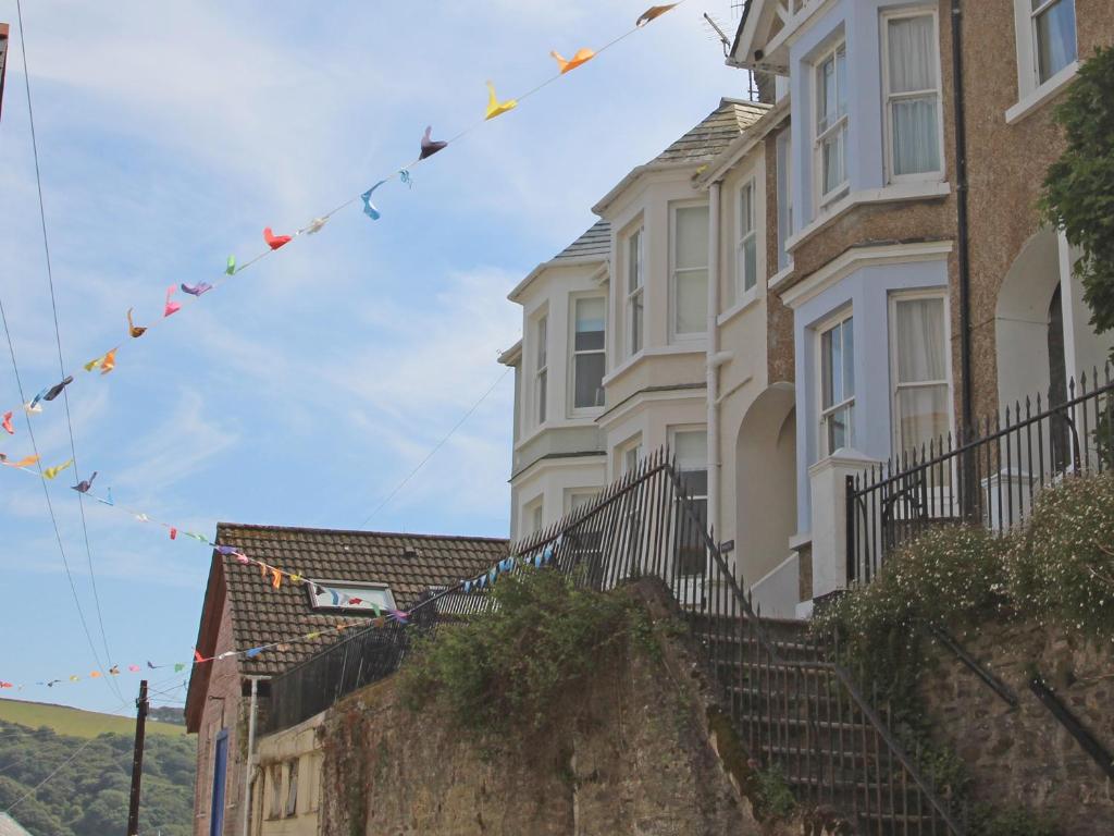 a row of houses with prayer flags hanging from them at Ferryside Watch in Fowey