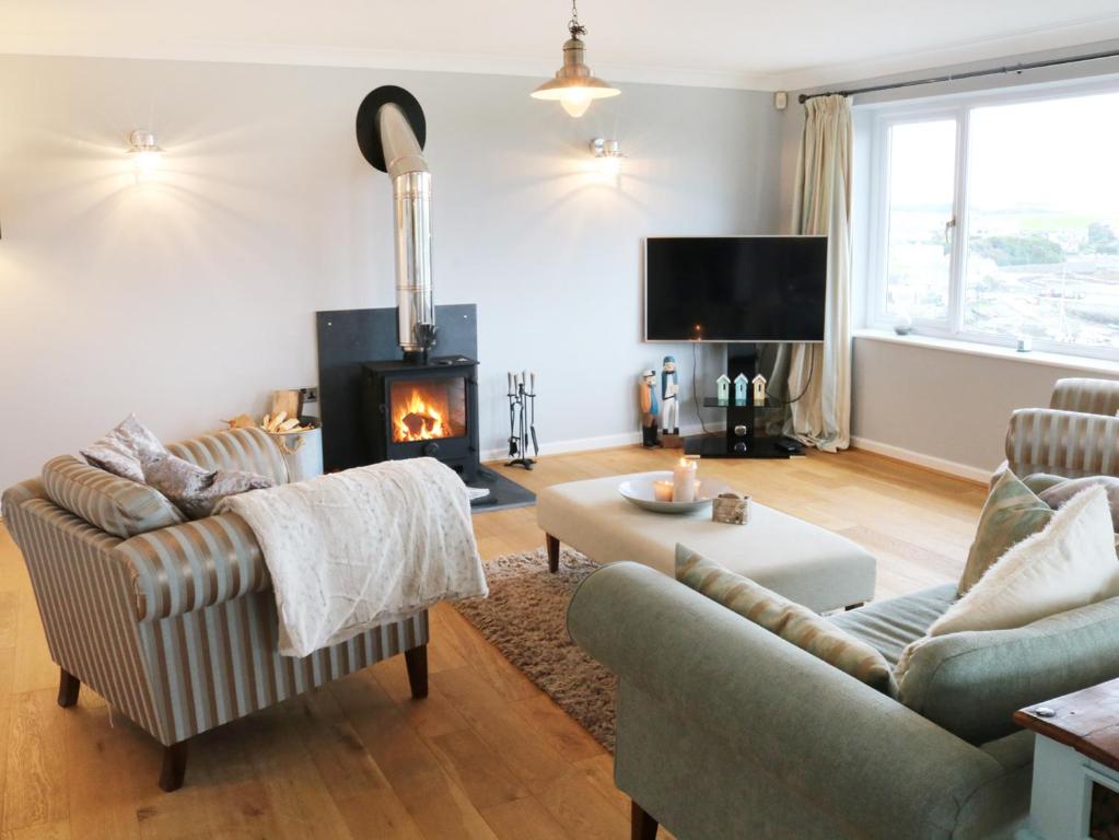 a living room with two couches and a fireplace at Cable House in Cemaes Bay