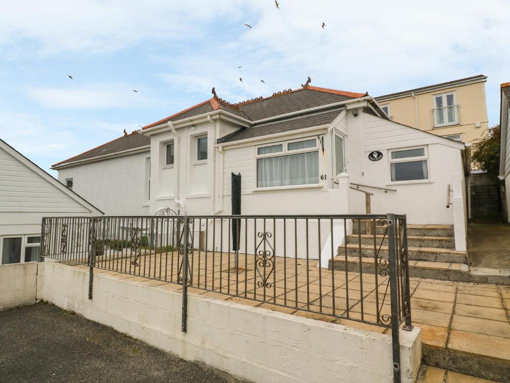 ein weißes Haus mit einem Zaun davor in der Unterkunft Treleigh in Hayle