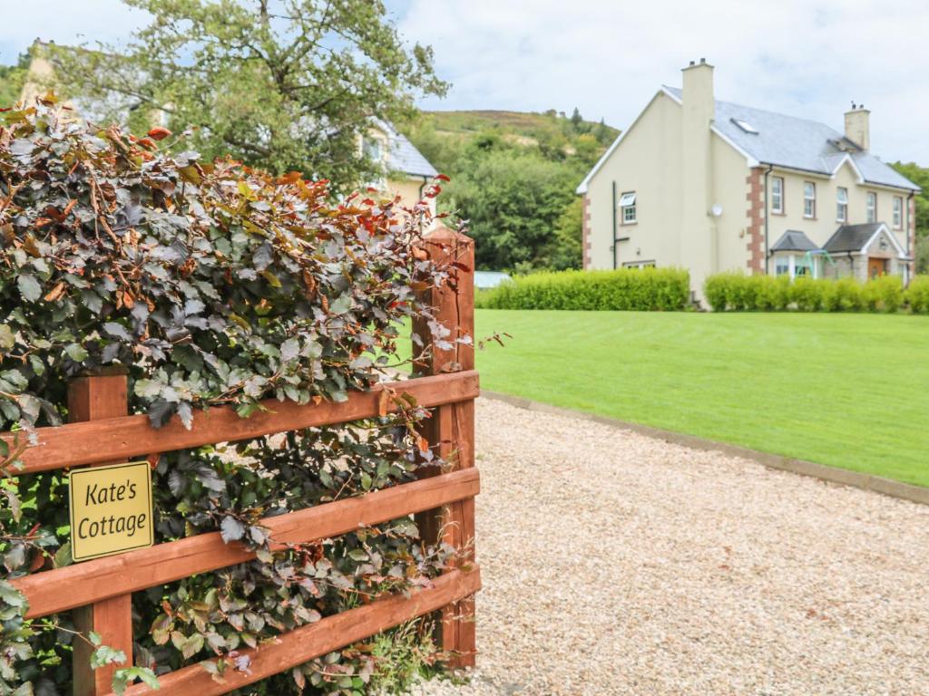a fence covered in ivy with a sign on it at Kate's Cottage in Rathmullan
