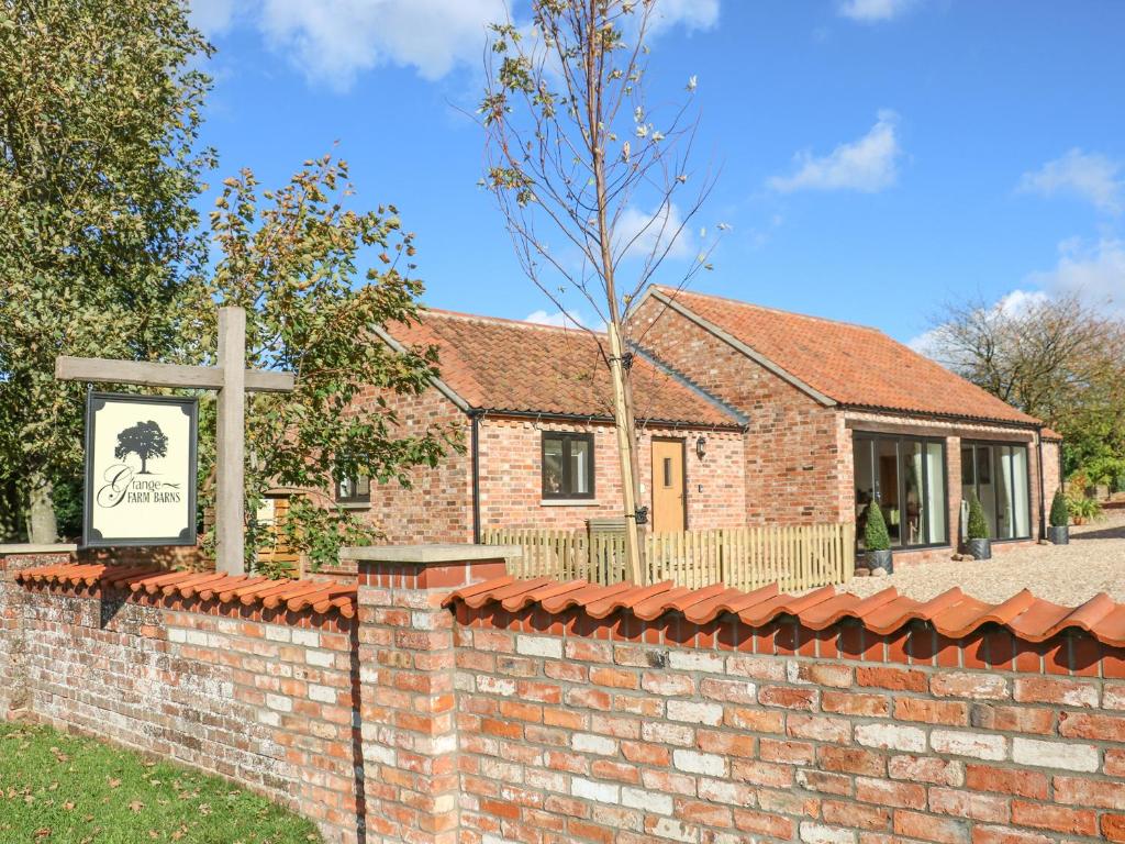 a brick church with a cross in front of a brick wall at The Cottage at Grange Farm Barns in Horncastle