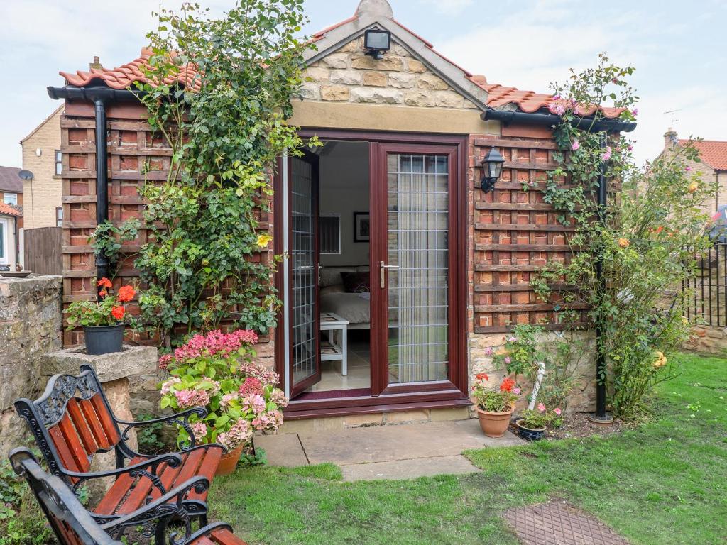 a garden shed with a bench in the yard at Kissingate in Mansfield