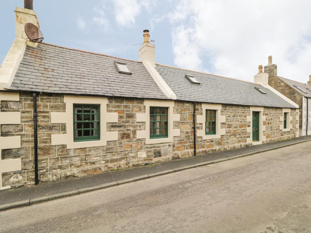 an old stone building on the side of a street at 83 Seatown in Buckie