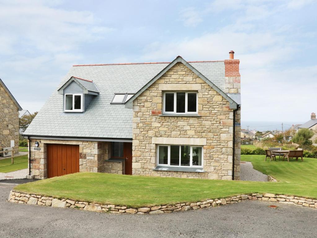 a large brick house with a grass yard at Myles View in Penzance