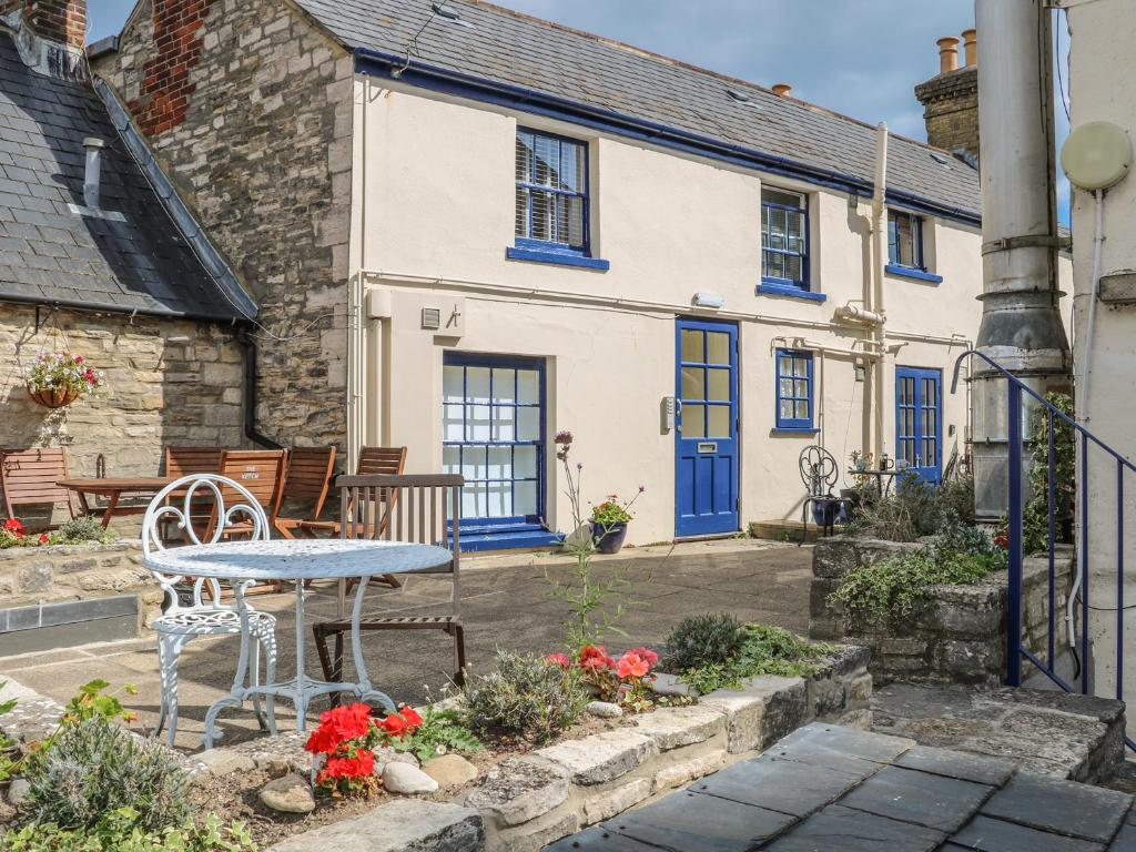 a house with blue doors and a table in front of it at The Compass in Swanage