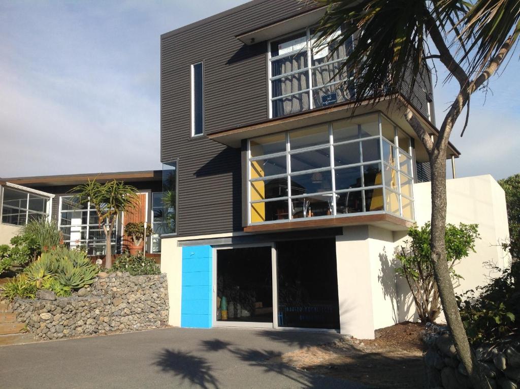 una casa en blanco y negro con muchas ventanas en Top Floor Bed and Breakfast, en Paraparaumu Beach